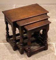 A nest of three 18th century style oak tables, late 20th century, the moulded tops upon baluster and