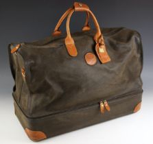 A Brics holdall type travel bag, the textured black leather body with tan leather handles and corner