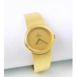 An 18ct yellow gold Omega DeVille ladies wristwatch, the textured gold oval face set to plain