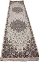 A fine woven Iranian runner, the ivory ground centred with a pair of embossed floral medallions,