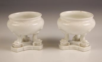 A pair of white glazed continental porcelain table salts, 19th century, each of cauldron form and