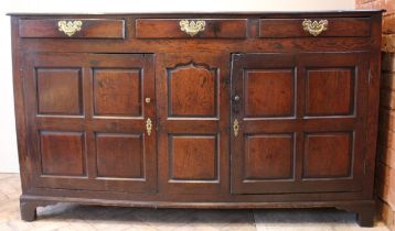 An 18th century oak dresser base, the twin plank moulded top over three lip moulded frieze drawers