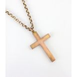 A yellow metal cross pendant, the plain polished pendant stamped ‘9ct’ upon an associated yellow
