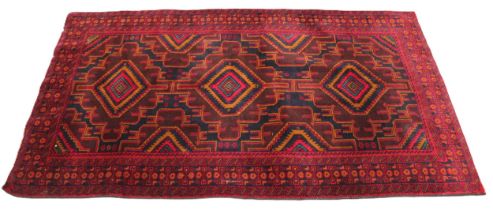 A fine woven rich red and blue ground Afghan Beluchi tribal rug, the three central radiating lozenge