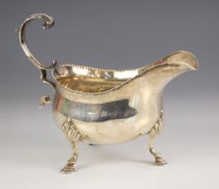 An Edwardian silver sauce boat, ‘TS’ London 1903, the flying handle above beaded rim and plain