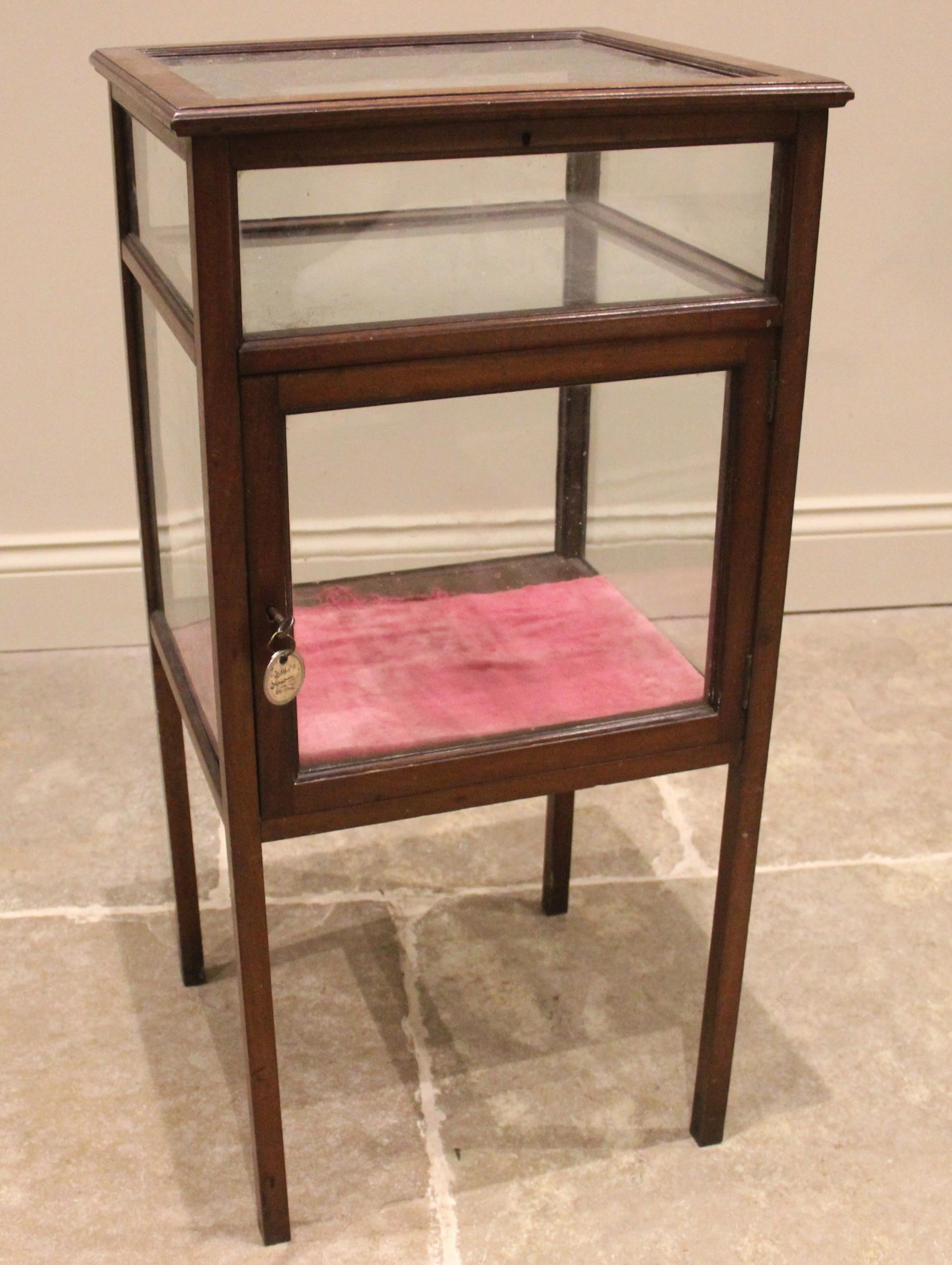 An Edwardian mahogany bijouterie cabinet, of cubic form, the hinged cover opening to an upper