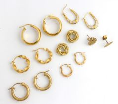 A selection of yellow metal and gold coloured earrings, including a pair of plain polished hoop