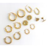 A selection of yellow metal and gold coloured earrings, including a pair of plain polished hoop