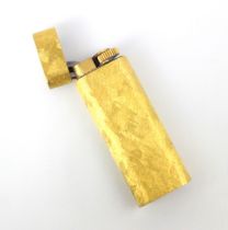 A Cartier gold plated lighter, the rectangular lighter with all over engraved detail, stamped to