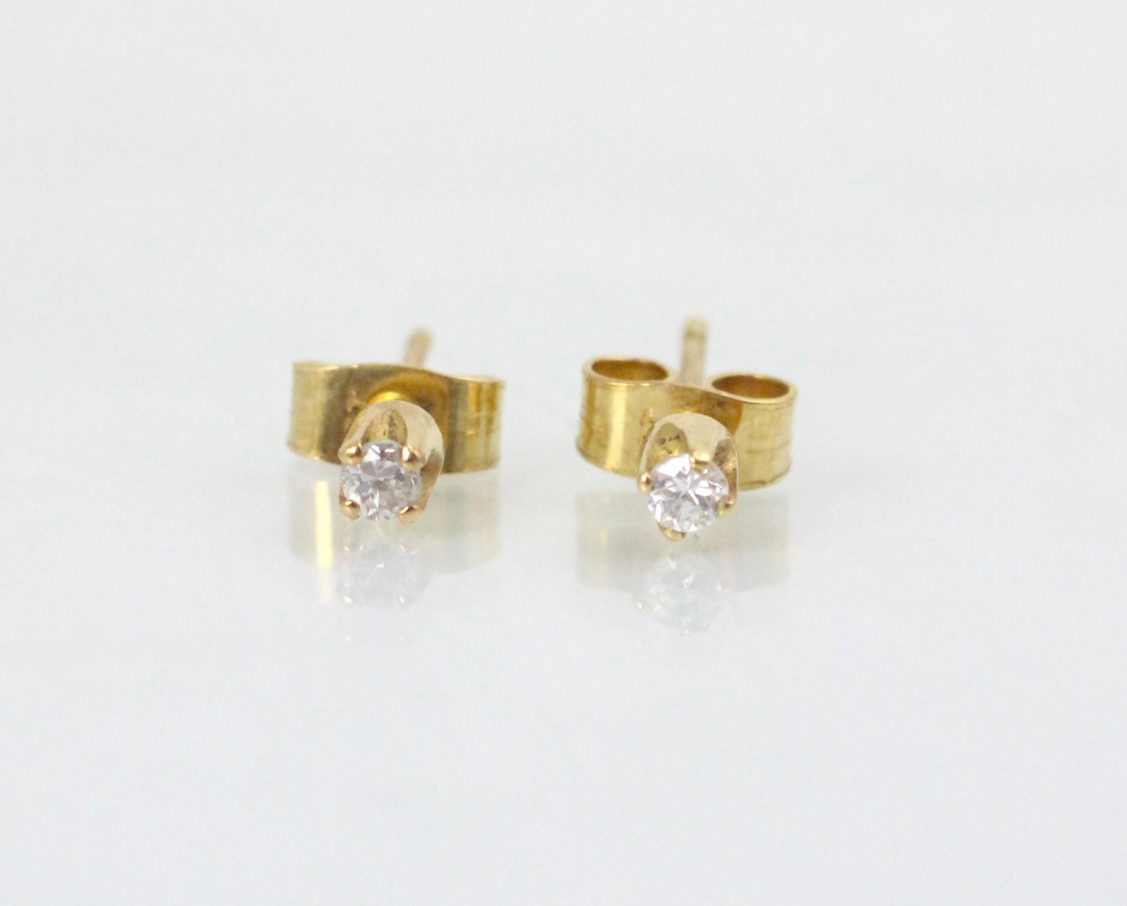 A pair of diamond stud earrings, the round cut diamonds in a four claw setting, with post and