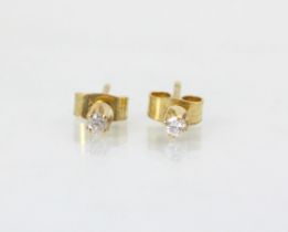 A pair of diamond stud earrings, the round cut diamonds in a four claw setting, with post and