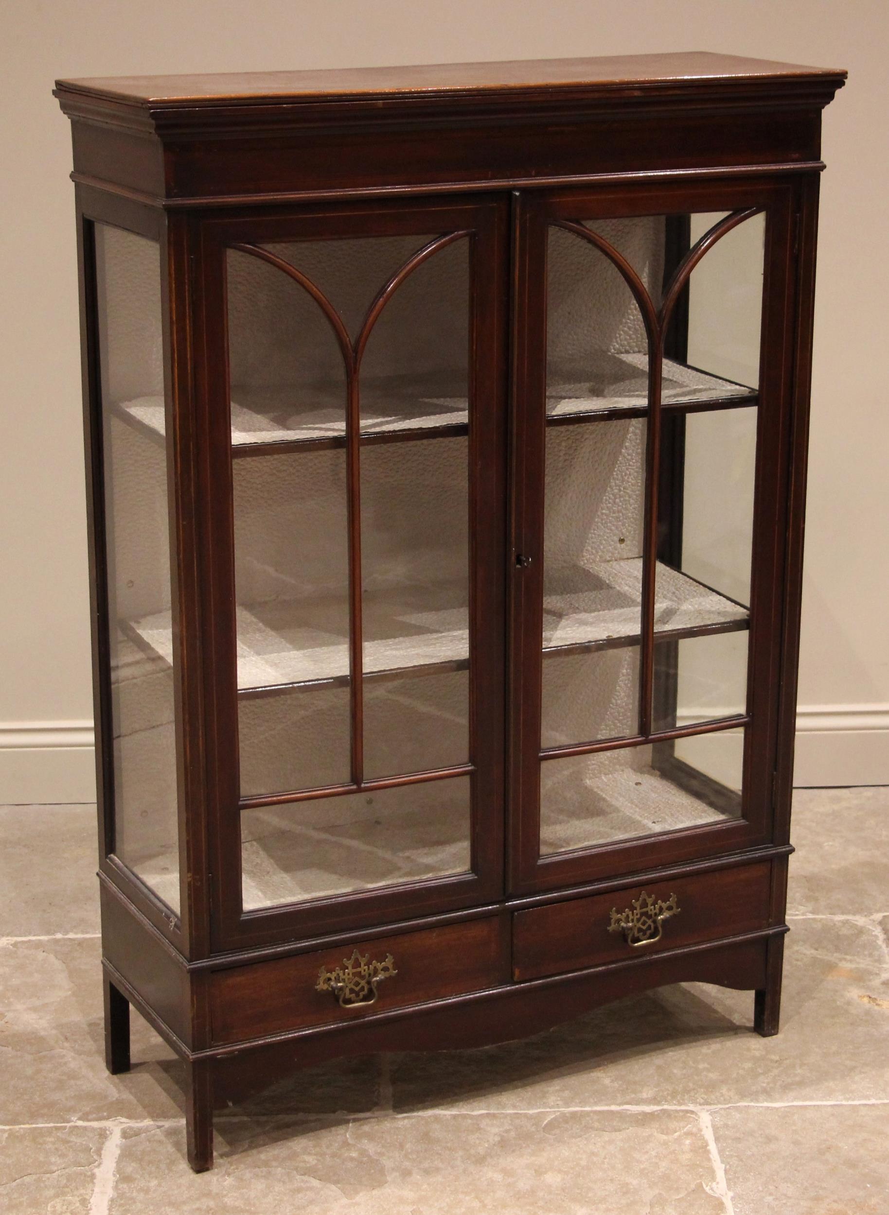 An Edwardian mahogany display cabinet, the crossbanded frieze over a pair of a arcaded astragal