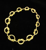 A yellow metal statement necklace, the graduated knot designed links with box and tongue fastener,