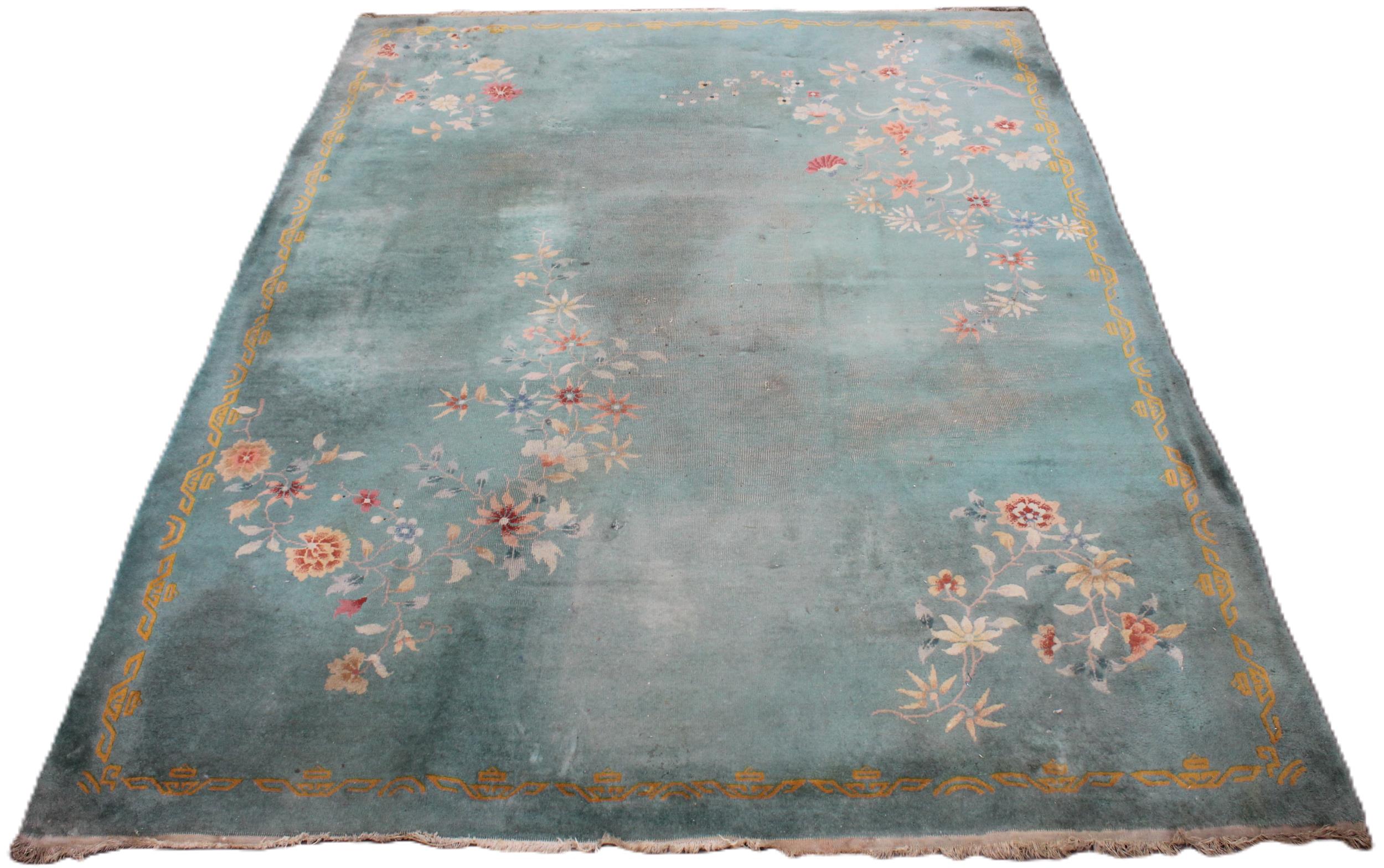 A large Chinese wool carpet, early 20th century, with floral motifs against a duck egg blue