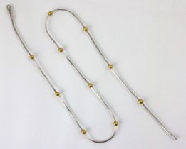 A 9ct white gold Italian necklace, the white gold snake like chain with ten yellow metal spherical