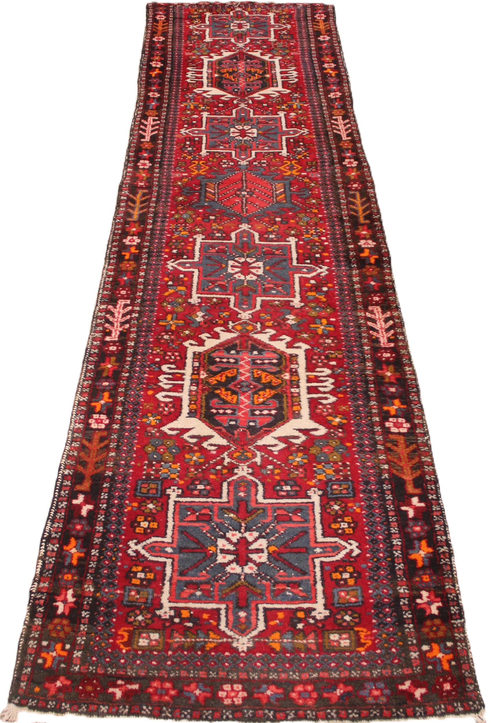 A North Iranian Persian Heriz runner, in red, blue and ivory colourways, the diamond medallion