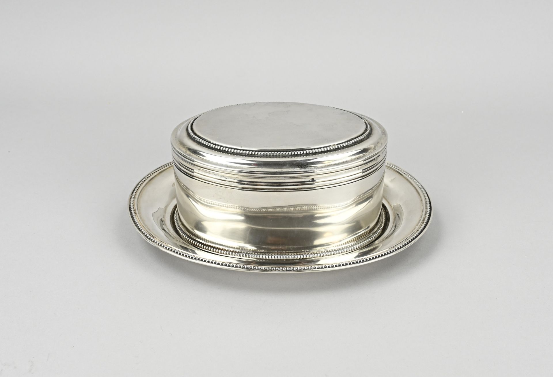 Silver cookie jar on saucer