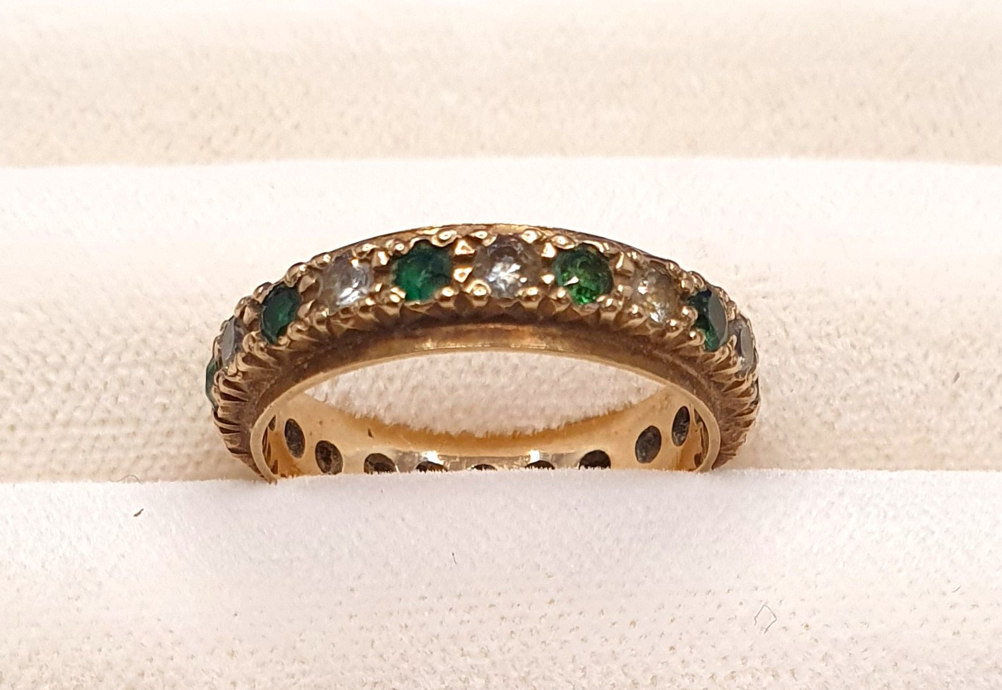 A 9ct yellow gold full eternity ring set with cubic zirconia and green paste stones, 2.48g, Size K