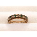 A 9ct yellow gold full eternity ring set with cubic zirconia and green paste stones, 2.48g, Size K