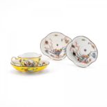 A PORCELAIN CUP AND THREE SAUCERS WITH YELLOW GROUND AND BIRD AND ROCK DECORATION