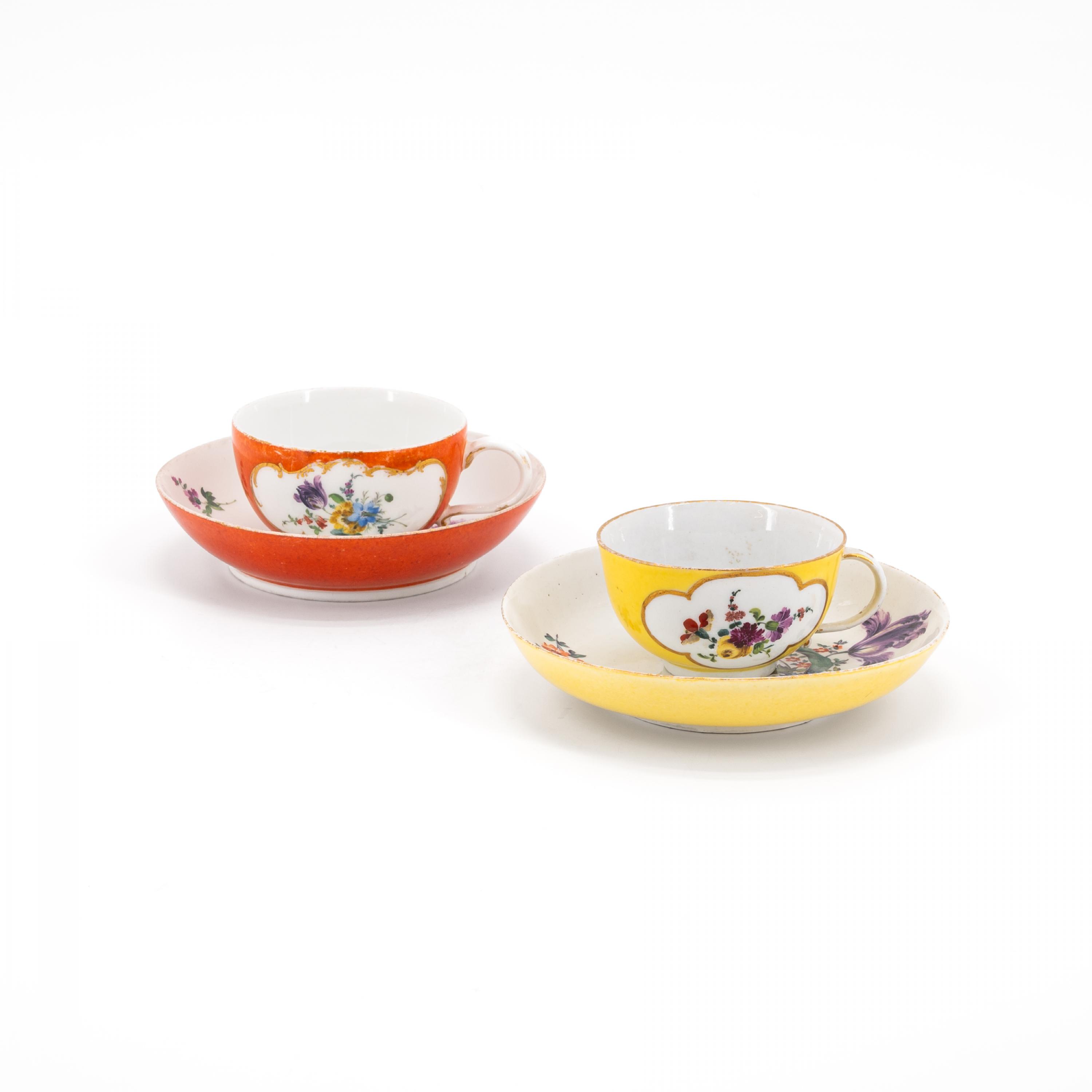 TWO PORCELAIN CUPS AND SAUCERS WITH YELLOW AND ORANGE COLOURED GROUND AS WELL AS FLORAL DECOR