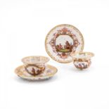 TWO PORCELAIN TEA BOWLS WITH SAUCERS AND CHINOISERIES IN CARTOUCHES WITH PURPLE LUSTRE