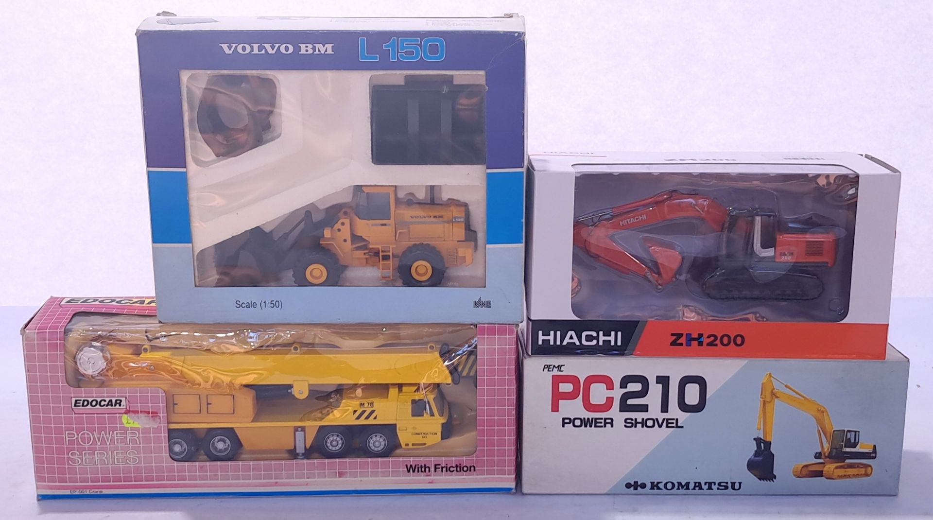 Hiachi, Komatsu and others, a mixed construction trio. Conditions generally appear Near Mint in g...