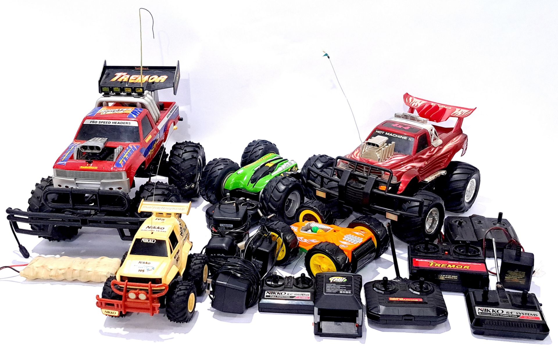 A large group of RC Vehicles with a range of controllers and plugs. Not checked for completion or...
