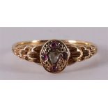 An 18 kt gold ring with a rose cut diamond and 4 rubies.
