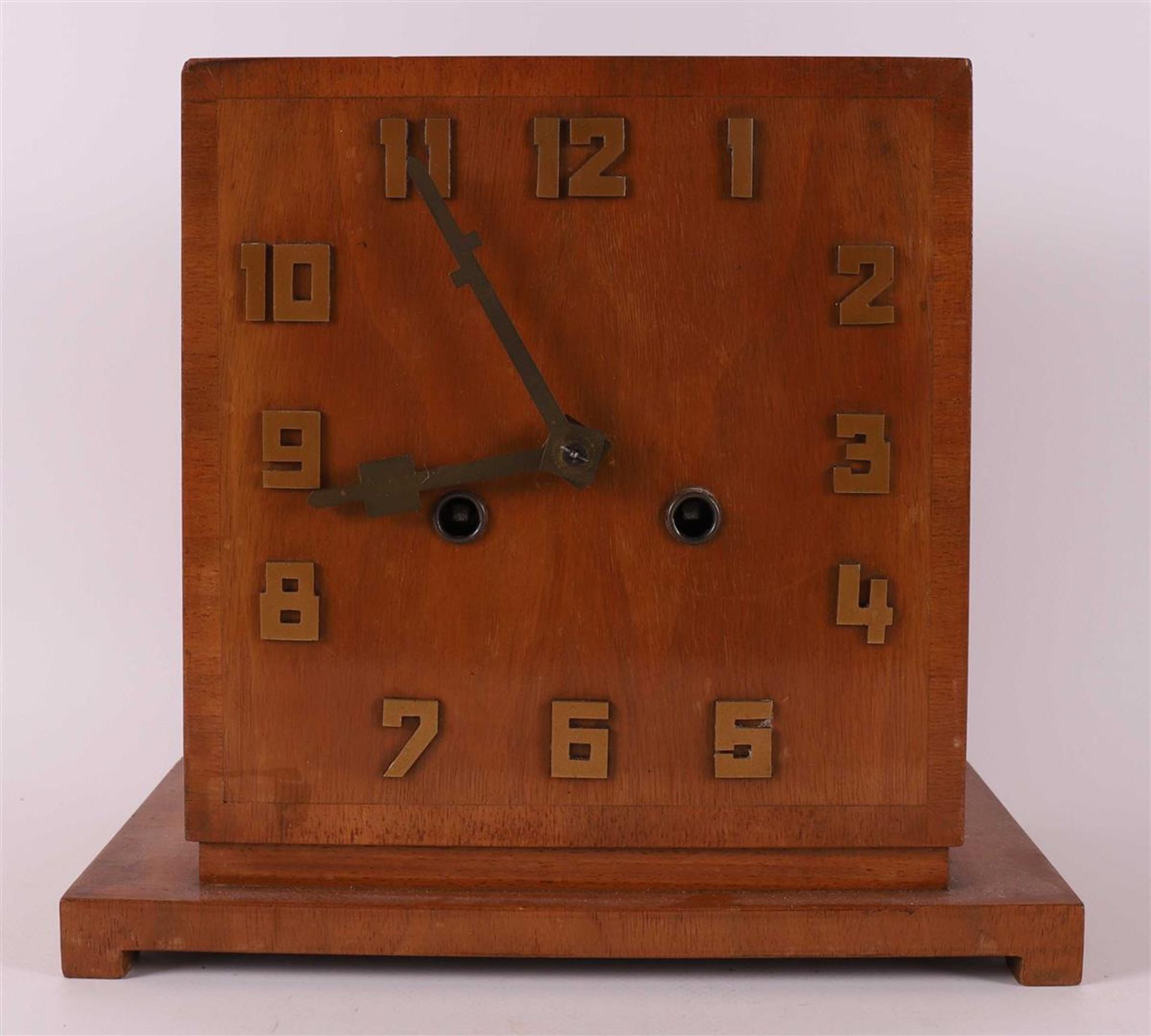 An Art Deco mantel clock in walnut casing, ca. 1930.