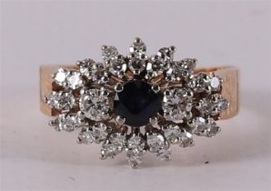 A 14 kt gold cluster ring with a facet cut blue sapphire.