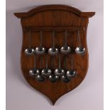 An oak spoon rack with pewter spoons, 20th century and earlier.