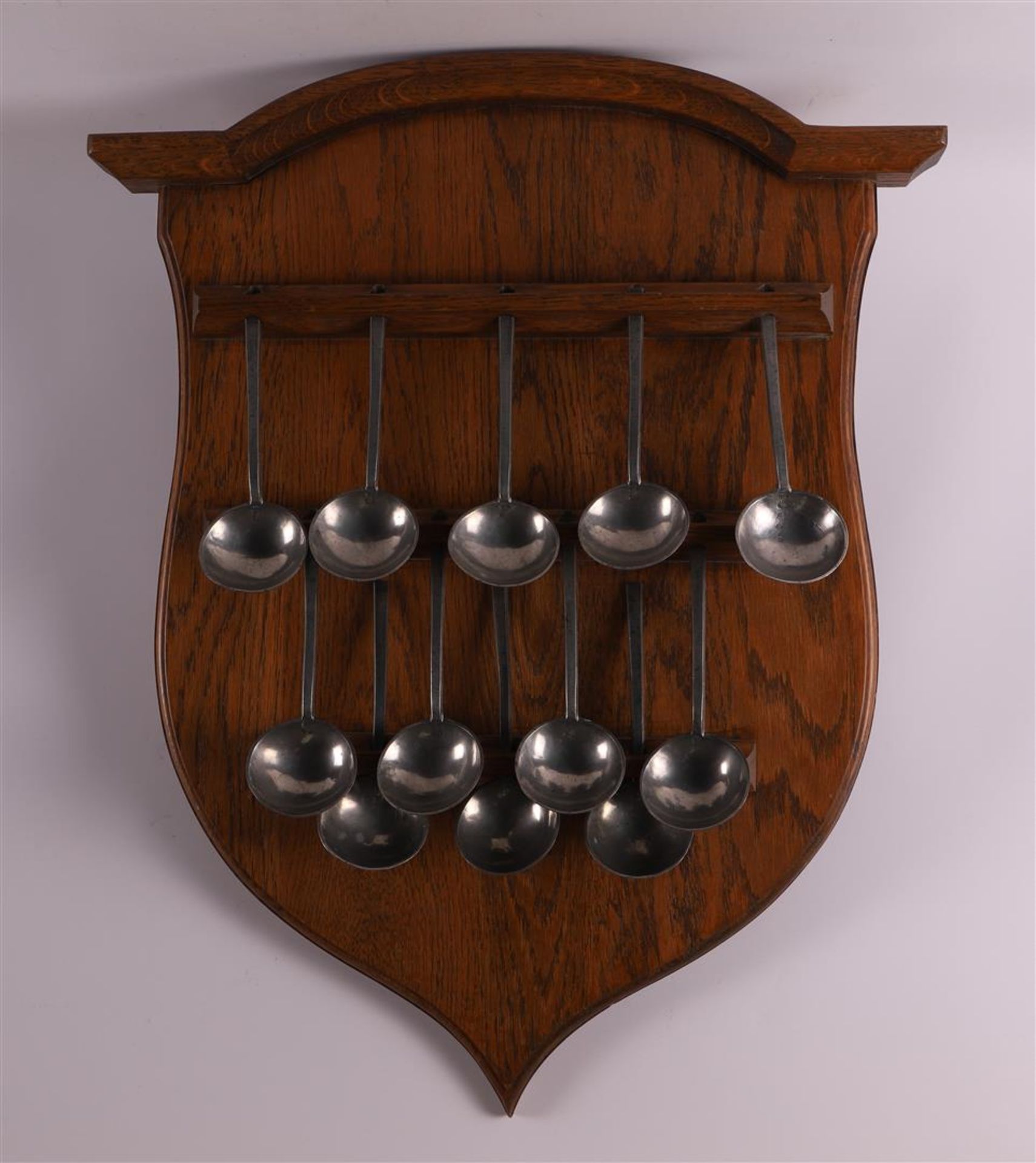 An oak spoon rack with pewter spoons, 20th century and earlier.