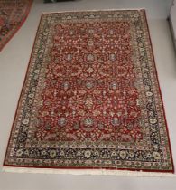 An Oriental wool carpet with round background and floral motifs, 20th century.