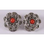 A pair of silver stud earrings with cabochon cut red corals and hematite.