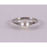A white gold solitaire ring set with a center pearl and 6 diamonds.