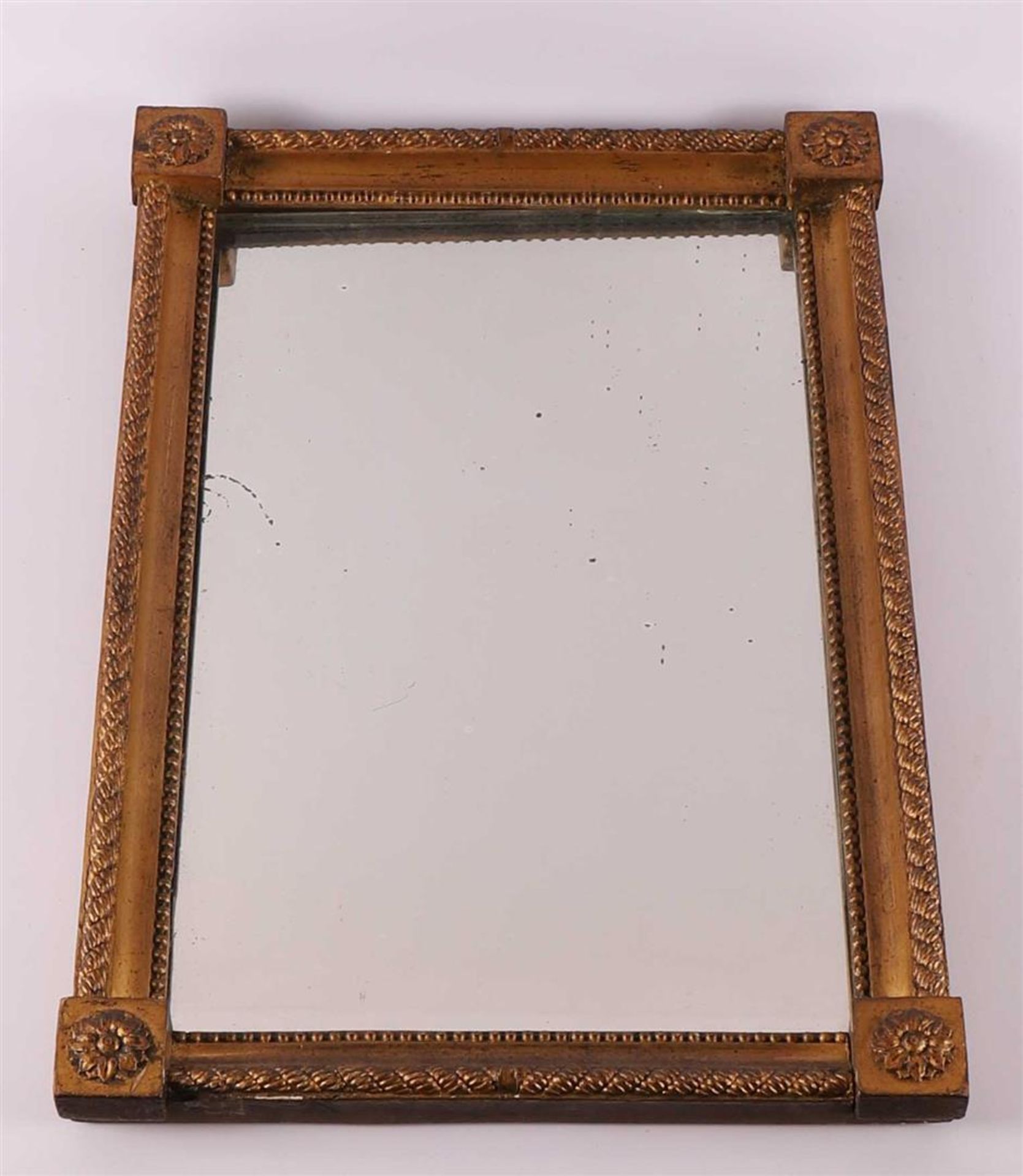 A rectangular mirror in a gilt frame with cable edge and rosettes,