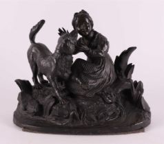 A bronze sculpture of a sitting girl with a dog, around 1900.