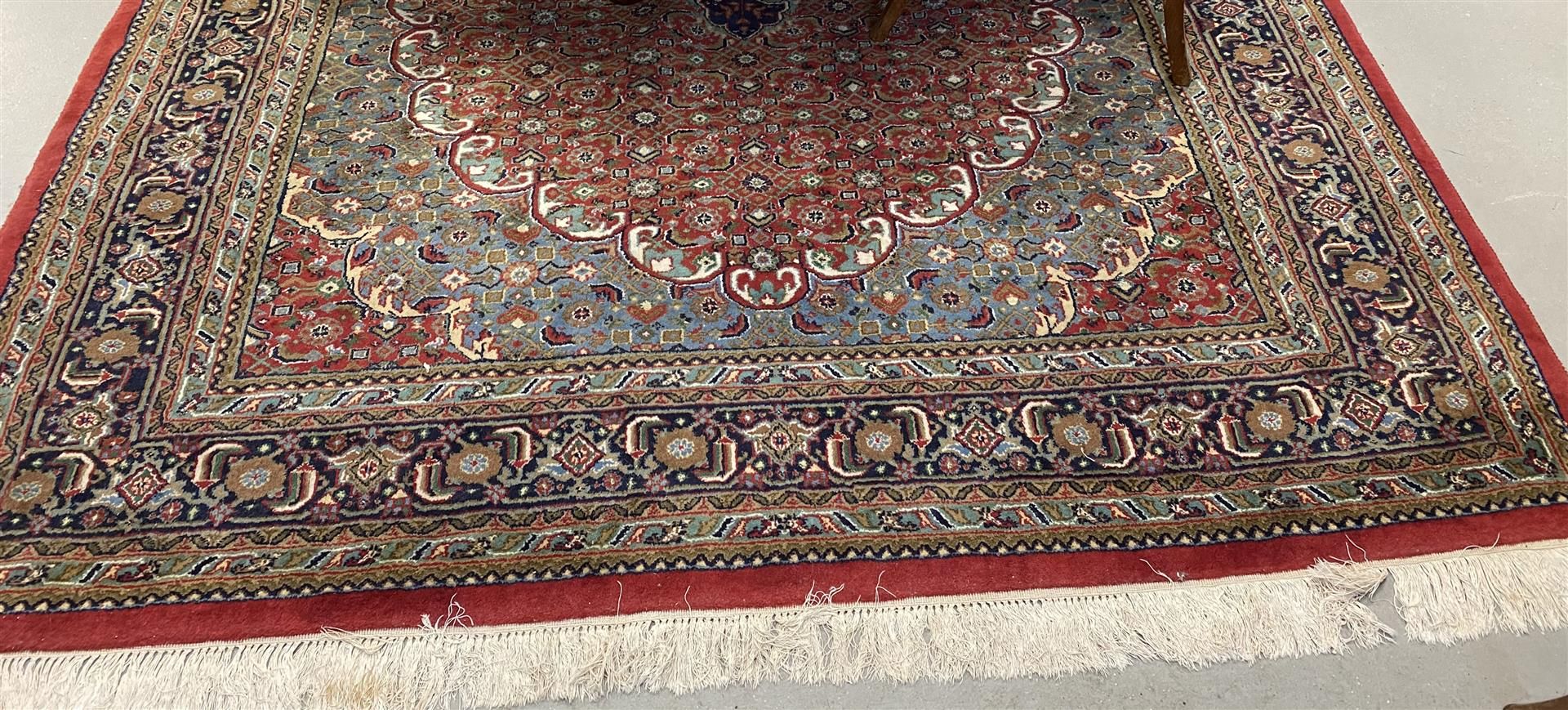 An Oriental wool carpet with round ground and floral motifs.