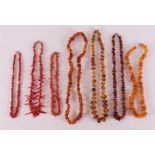 A lot of various necklaces, including amber and sticks of red coral.