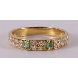 An 18 kt gold ring with 2 baguette cut emeralds and 24 diamonds.
