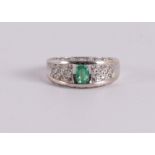 An 18 kt gold band ring with an oval facet cut emerald