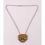A 14 kt gold filigree pendant on a ditto gold necklace.