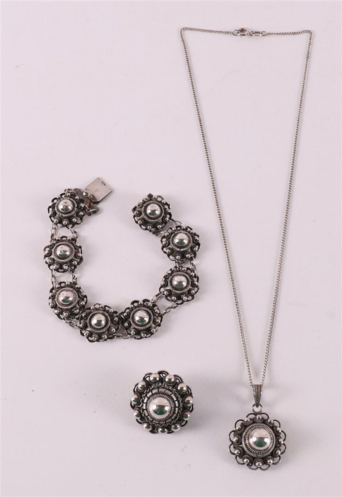 A silver Zeeland knot bracelet, brooch and pendant on a necklace.
