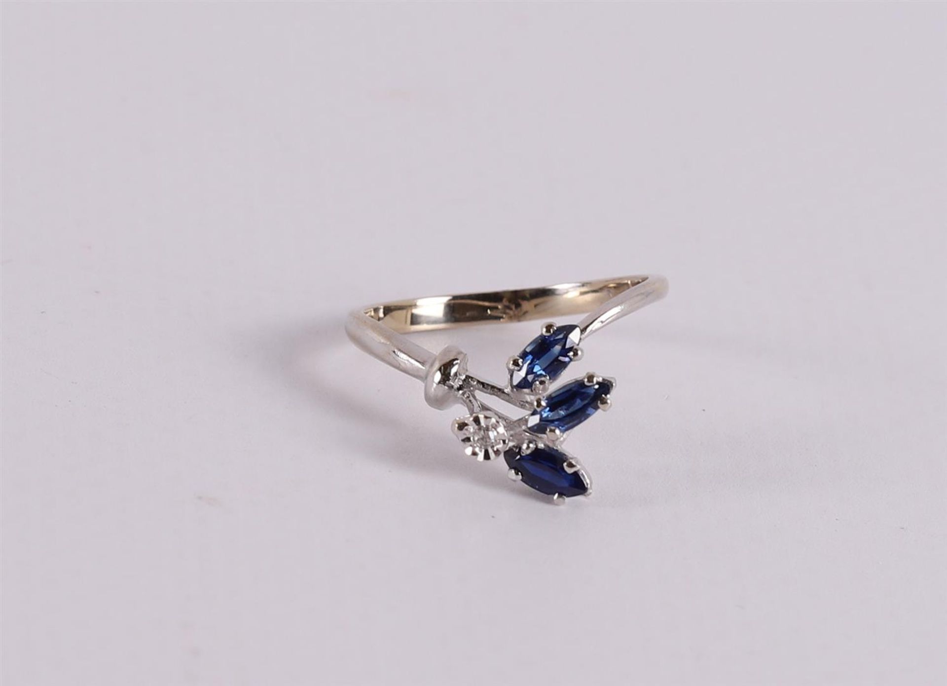 An 18 kt gold ring with 3 marquise cut blue sapphires and a diamond