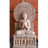 A carved wooden sitting Buddha in lotus position on a throne, India.