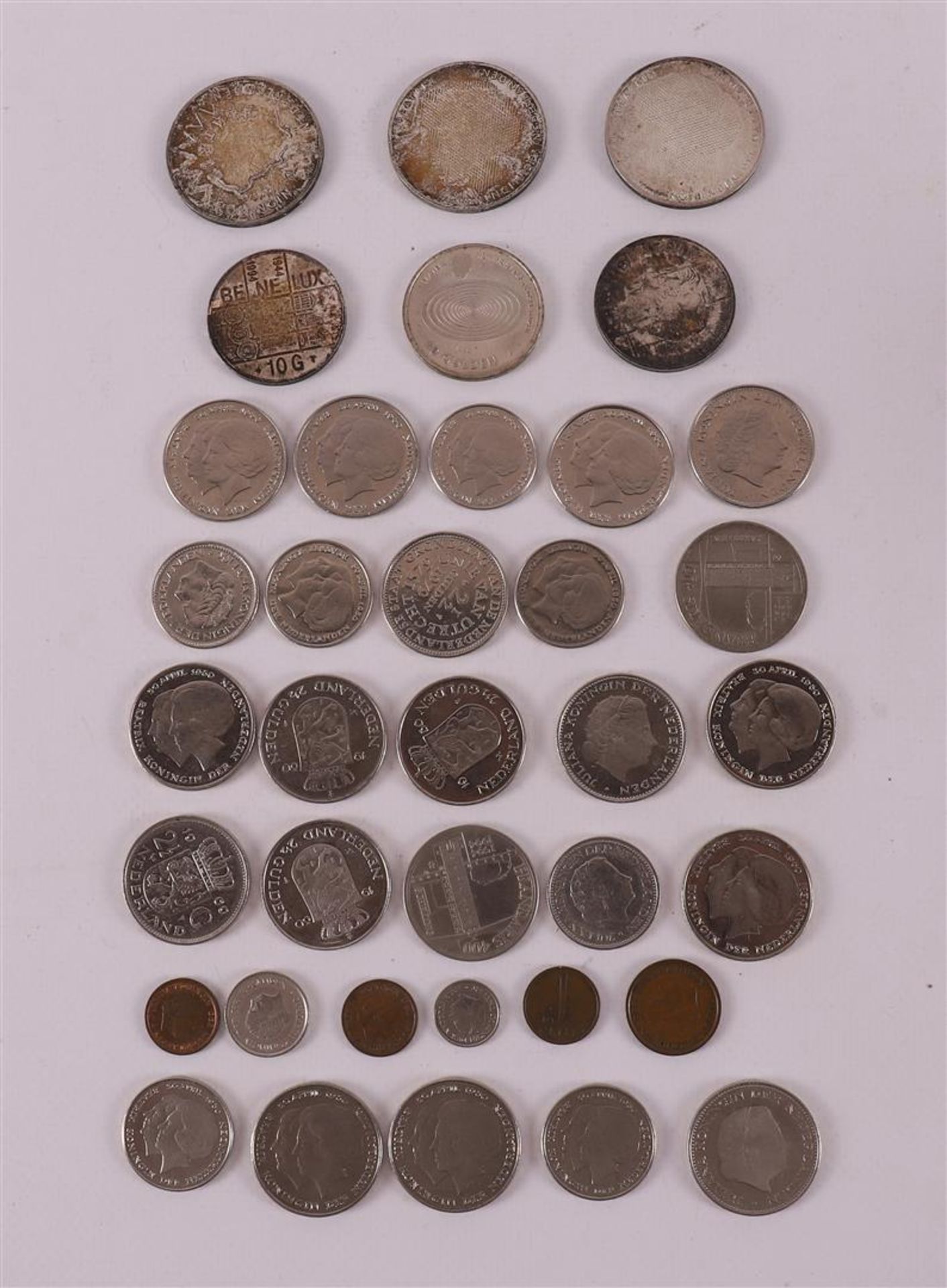 A lot of various Dutch coins, including 3x 50 guilders and 3x 10 guilders.