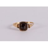 An 18 kt 750/1000 gold ring with a facet cut garnet, 19th century