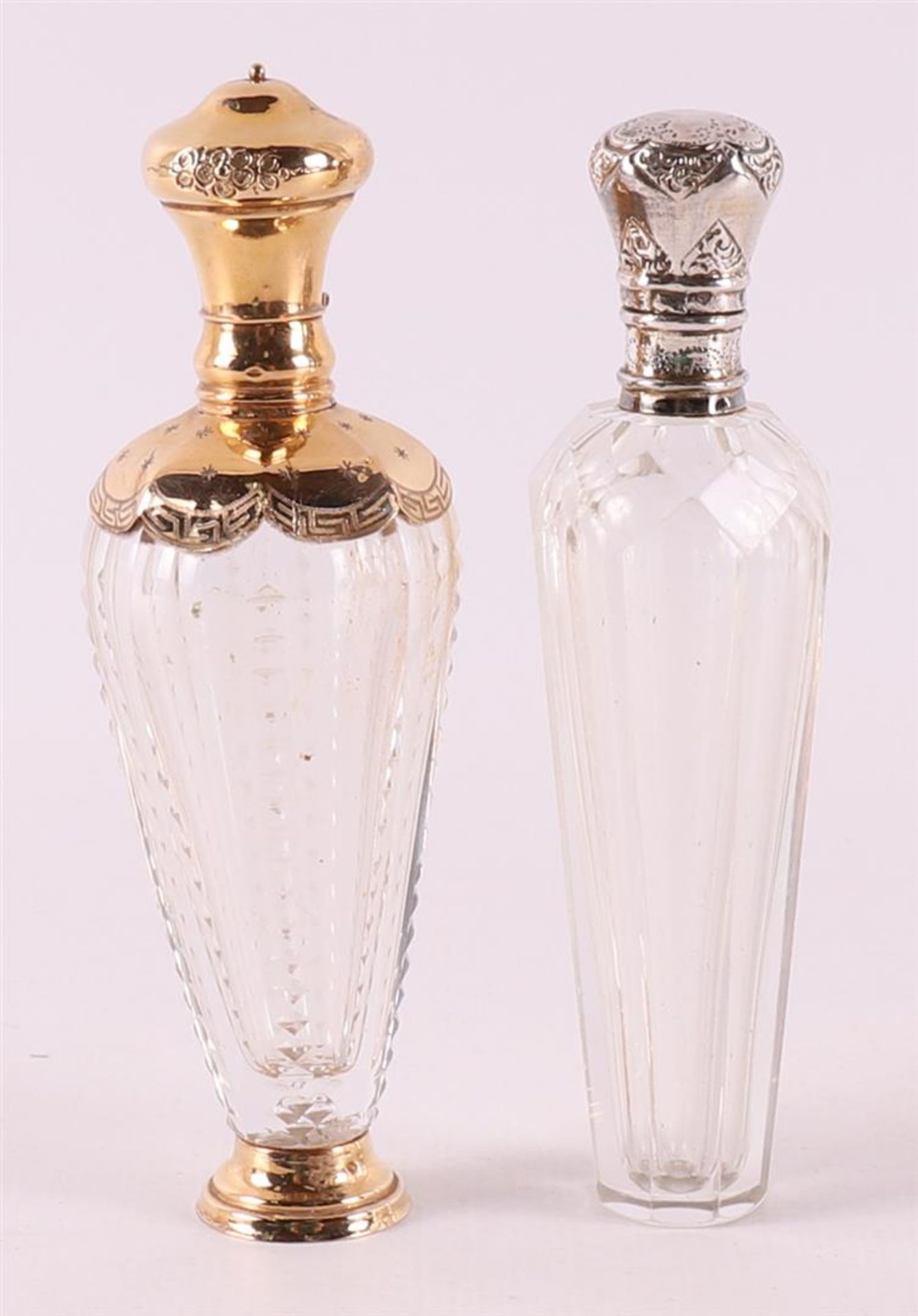 A clear crystal odor flask with gold lid and frame, around 1900.