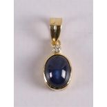 An 18 kt gold pendant with a cabochon cut blue sapphire and a brilliant cut diam